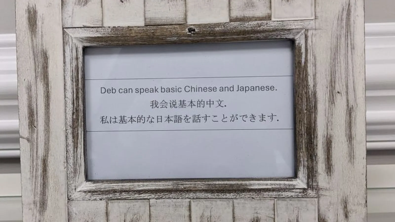 A framed sign noting that Deb speaks basic Chinese and Japanese