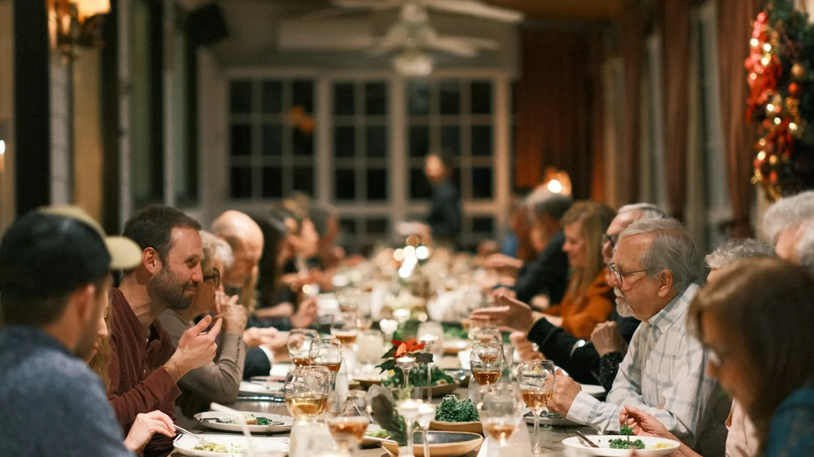 An extended family gathered around a long holiday dinner table